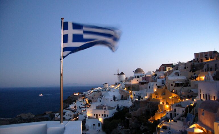 Flag of Greece waving at pole at Santorino, Greece
